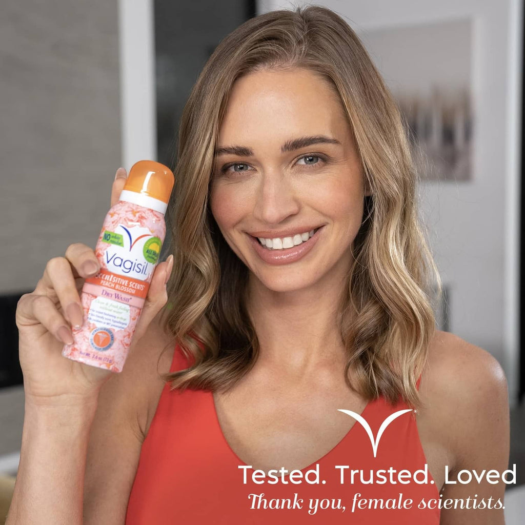 Vagisil dry wash deodorant spray bottle in hand, peach blossom scent, orange cap