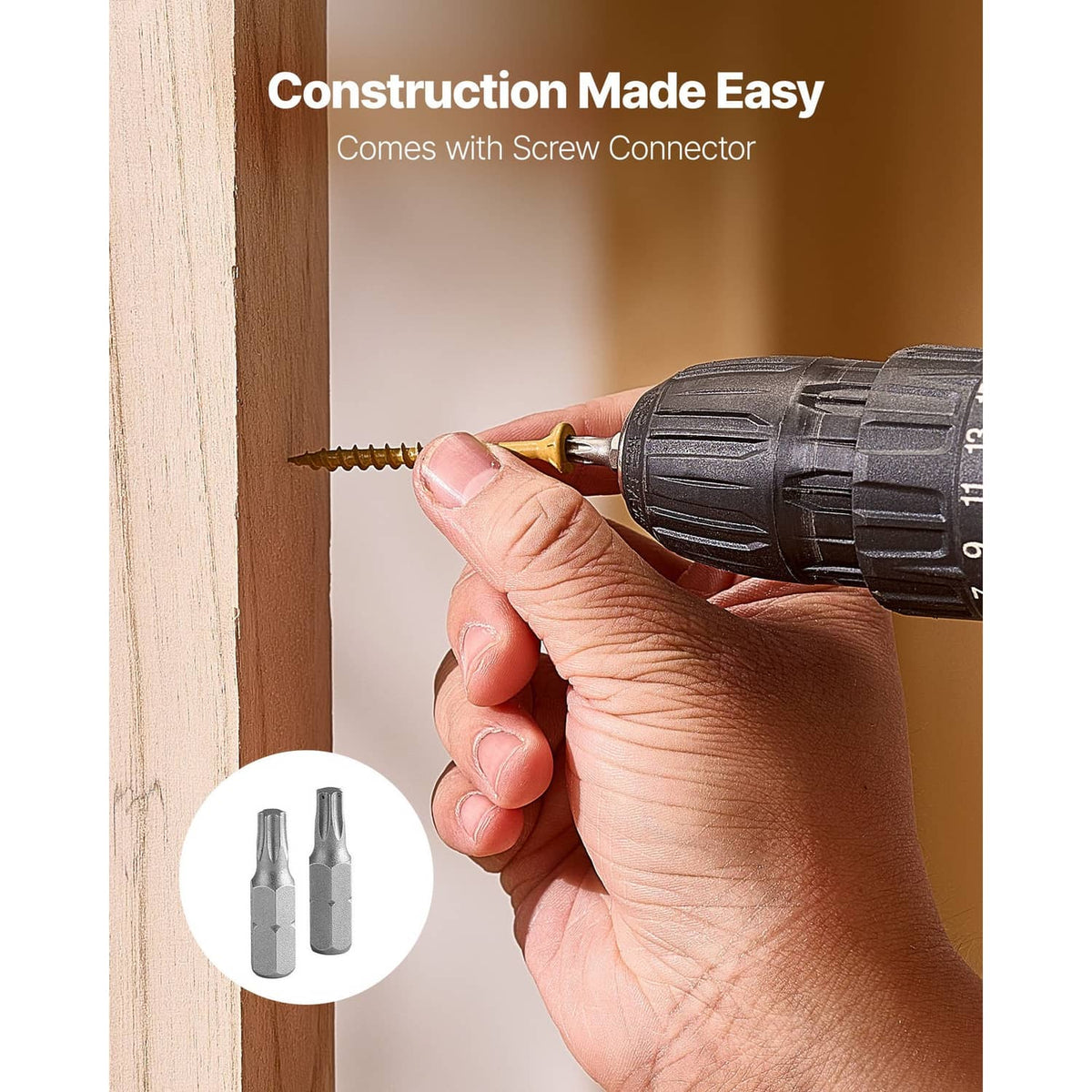 Hand driving a gold wood screw into a wall opening with a drill