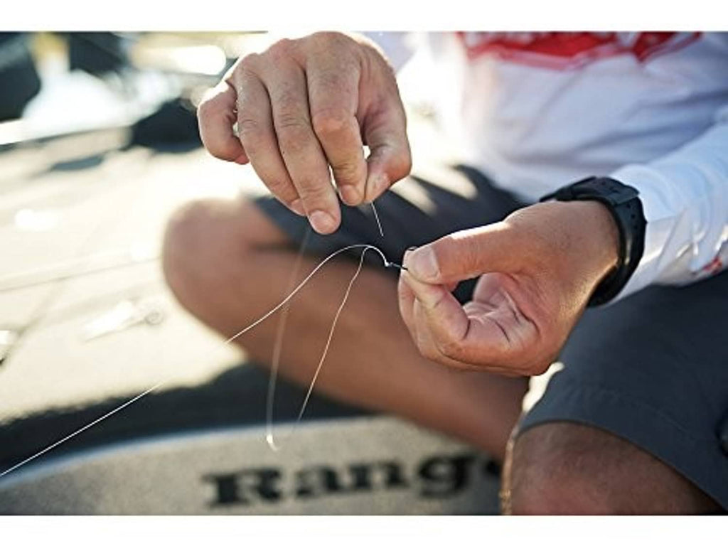 Hands tying fishing line loop; line stretches between fingers