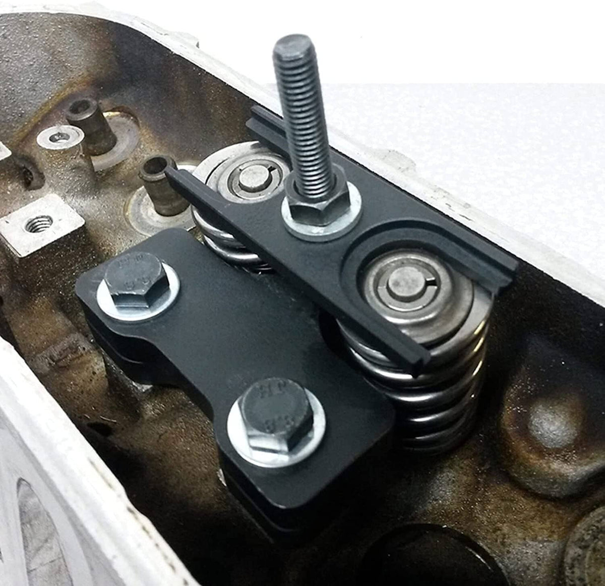 Valve spring compressor tool compressing coil springs on an engine cylinder head