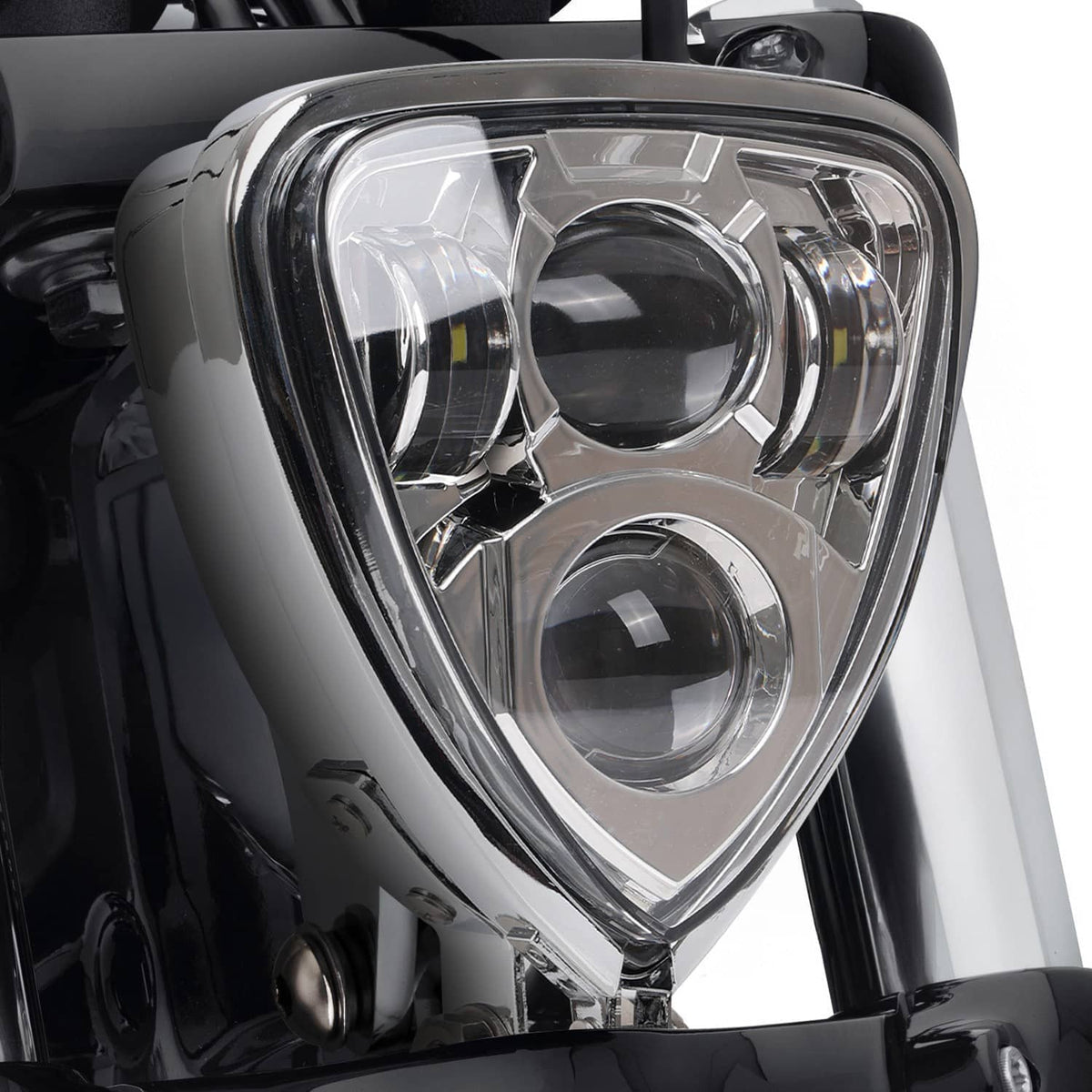 Close-up of triangular chrome headlight lens and reflector details, mounted view, side angle.