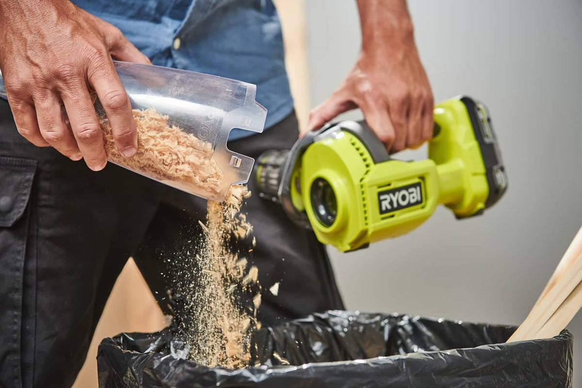 Handheld vacuum cleaner cleaning upholstery, clear nozzle and lime green body
