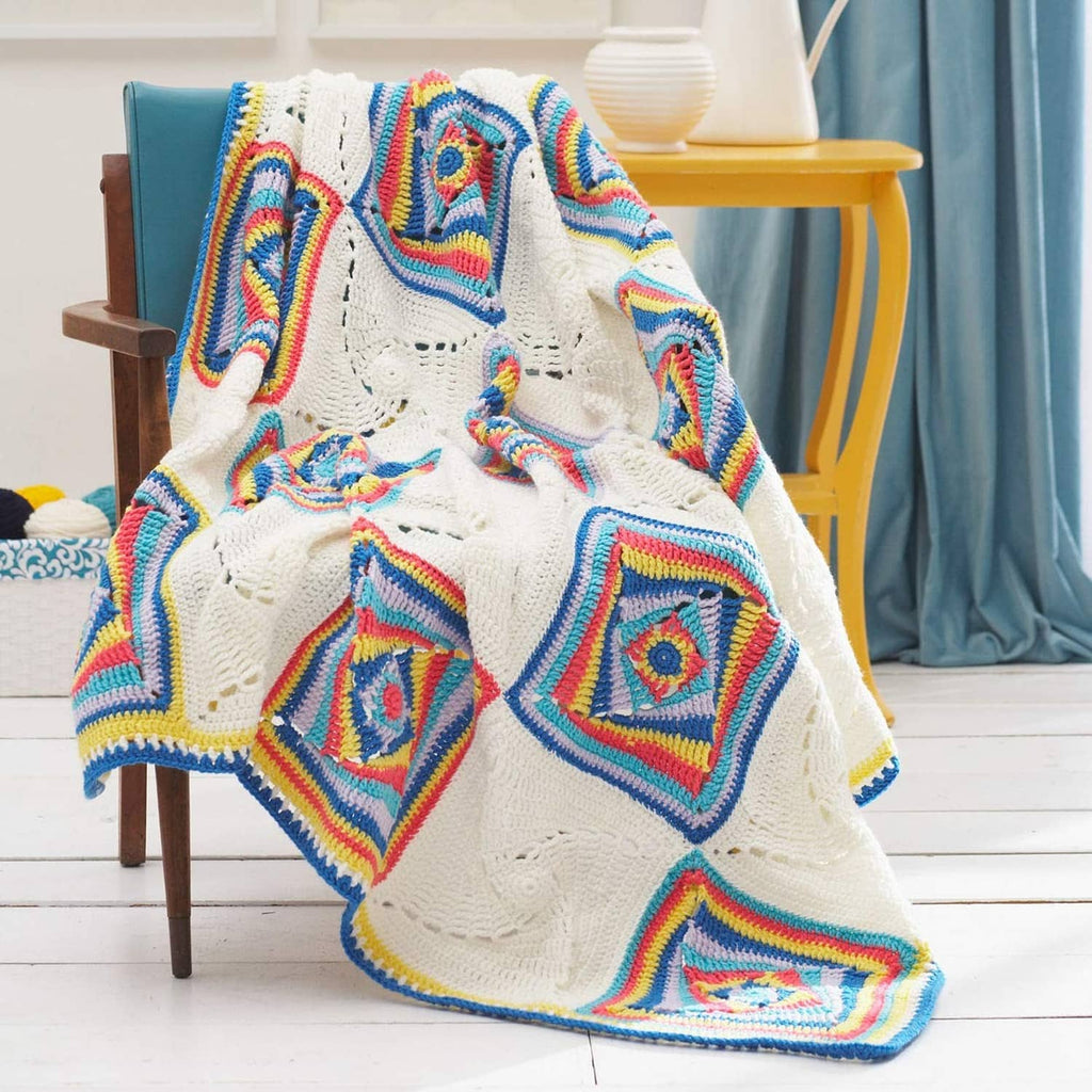 Colorful crocheted throw blanket with rainbow square motifs and white edging