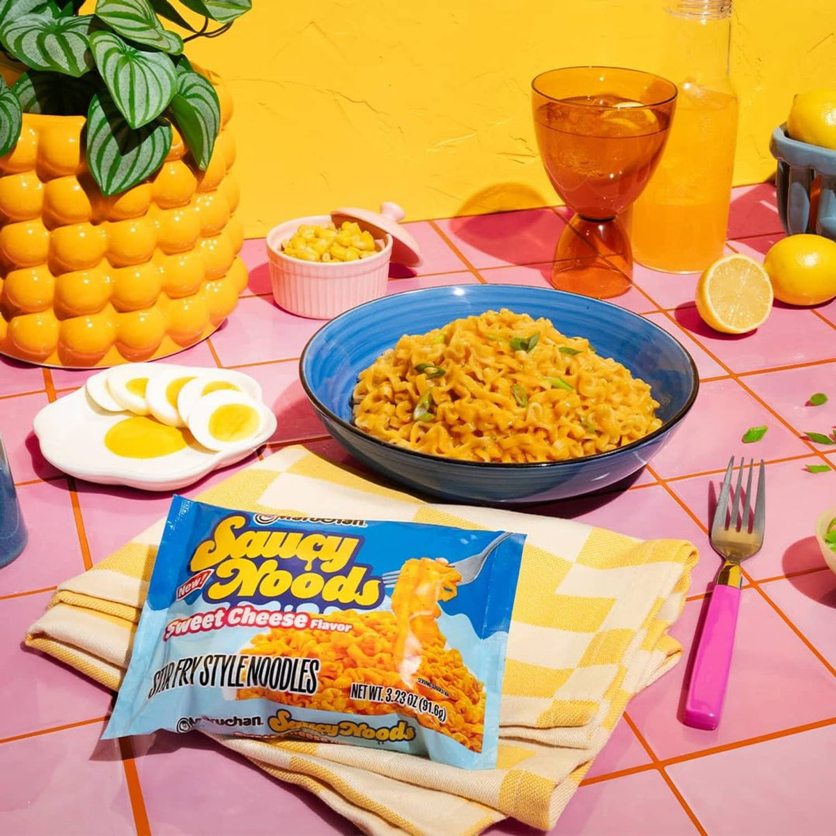 Maruchan Saucy Noods Sweet Cheese flavor packet with bowl of saucy noodles