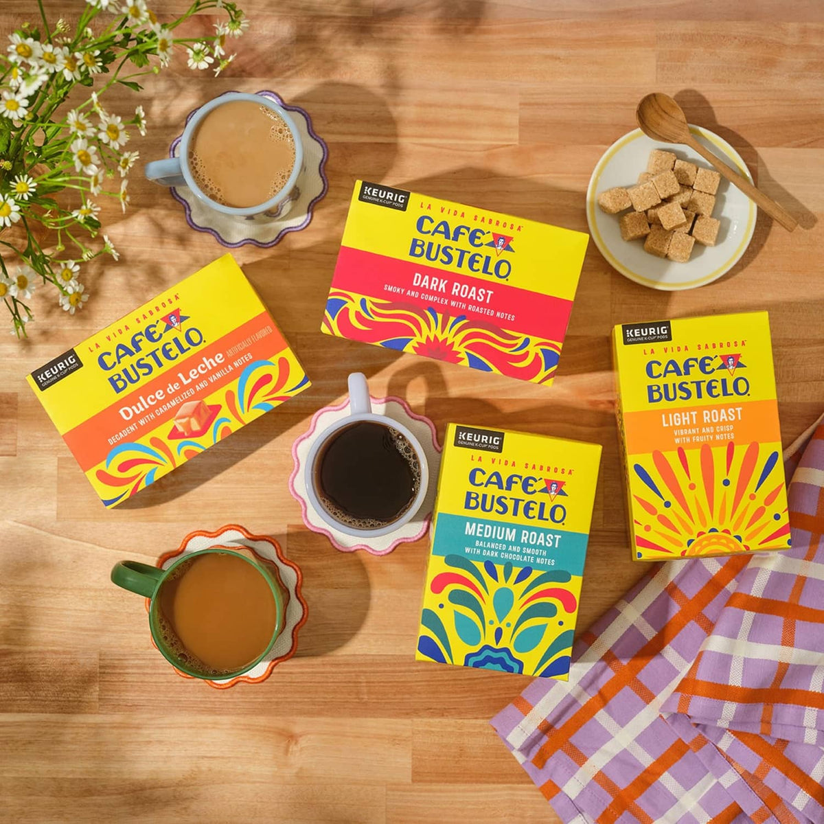 Cafe Bustelo roast variety coffee pods and cups arranged on a wooden table