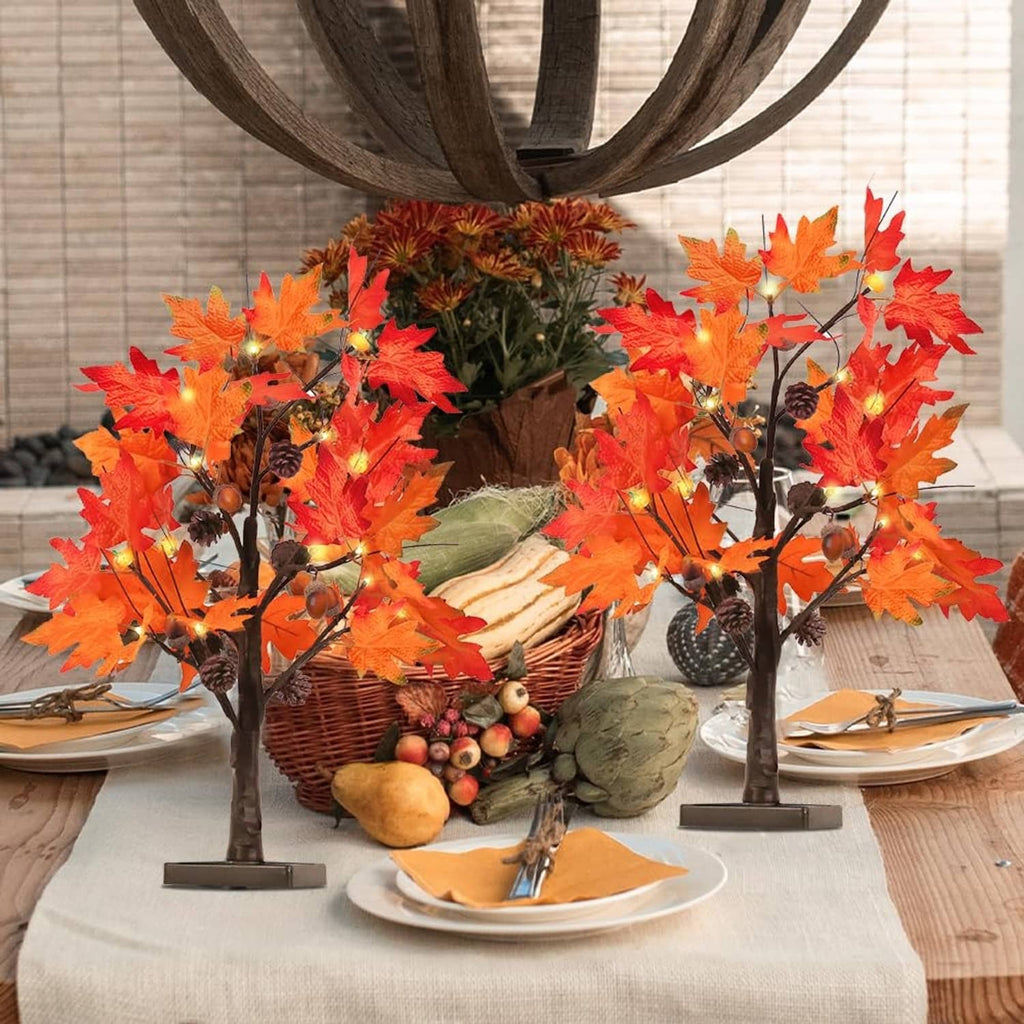 Two autumn lighted maple leaf trees on display with seasonal table decor