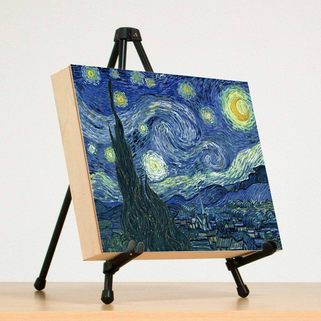 Tabletop easel stand holding a canvas panel with blue night landscape and clamps