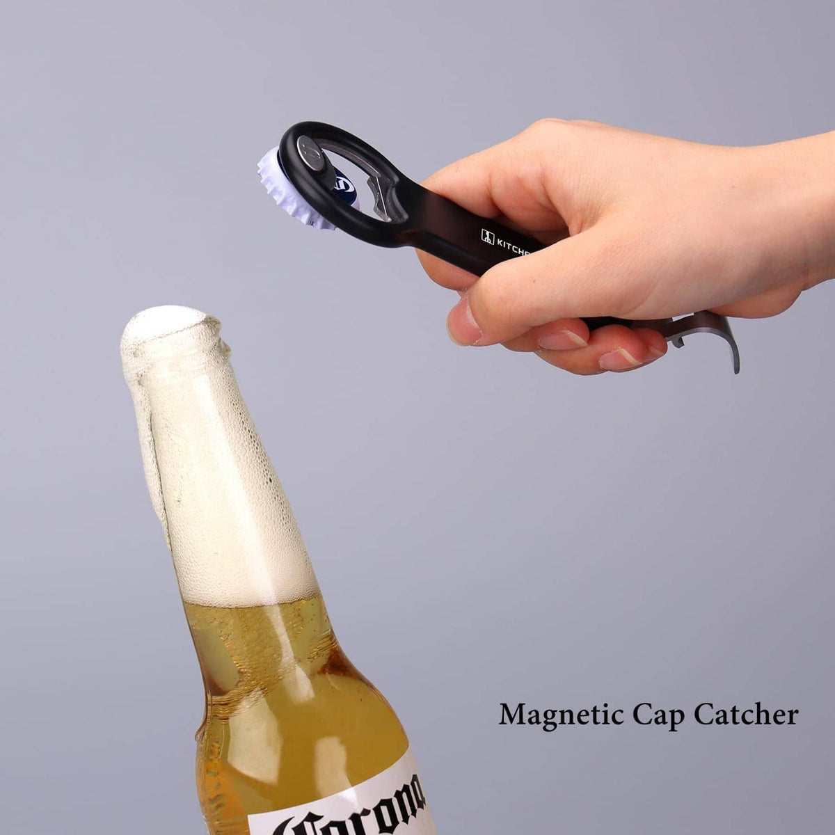 Black magnetic cap catcher opener with silver blade removing a bottle cap