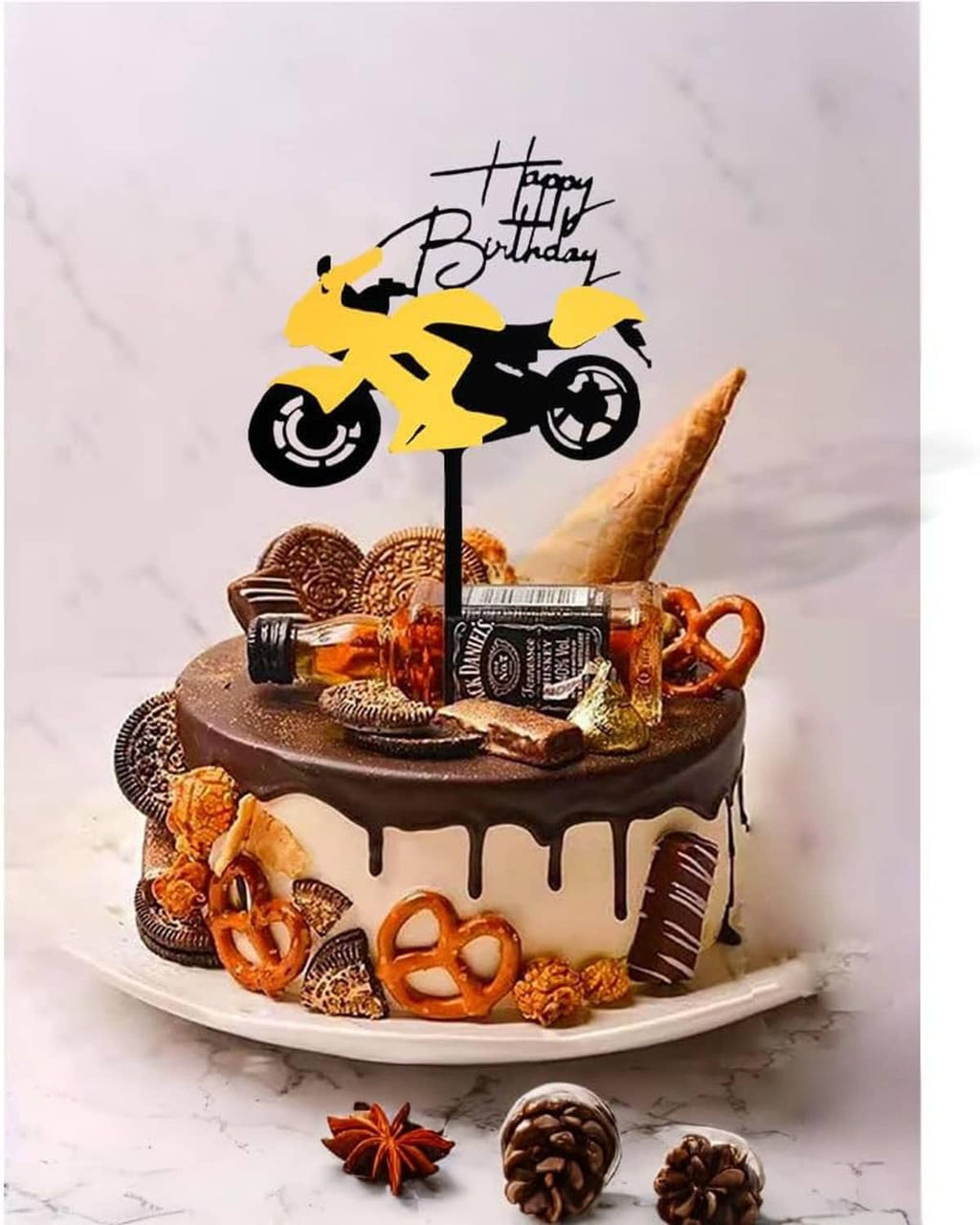 Motorcycle cake topper standing on a decorated cake with 'Happy Birthday' banner