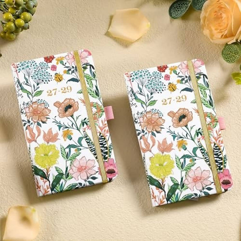 Two-pocket monthly planners with floral covers, gold elastic bands, and ribbon bookmarks
