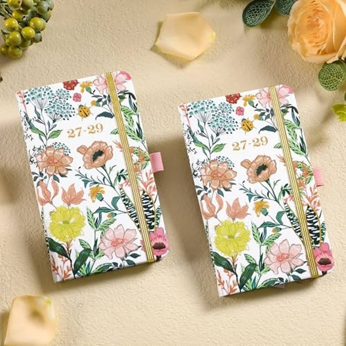 Two-pocket monthly planners with floral covers, gold elastic bands, and ribbon bookmarks