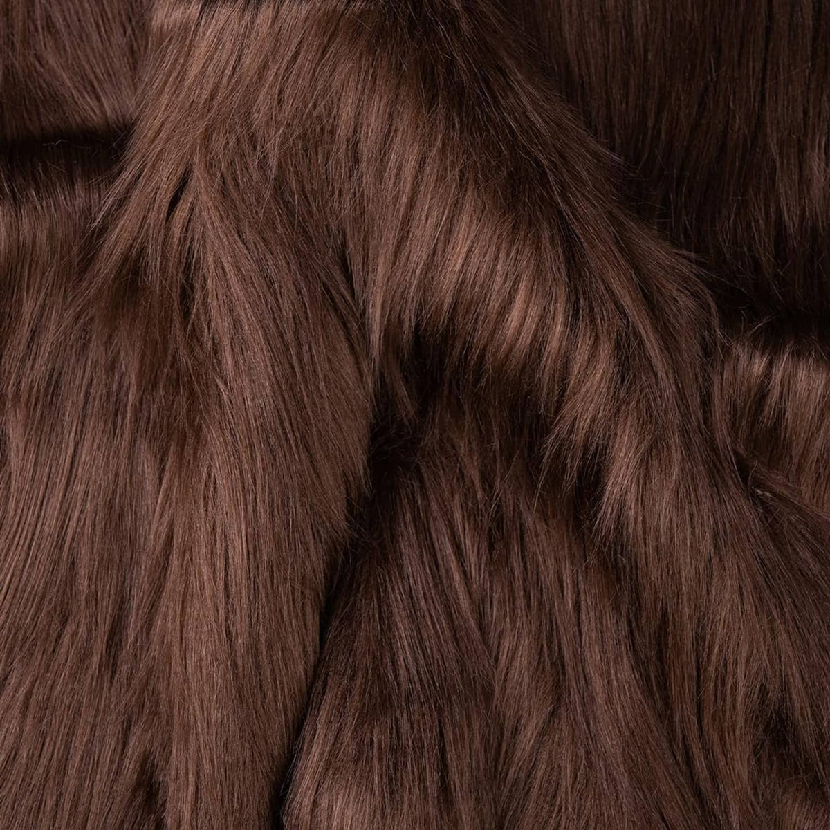 Brown faux fur fabric texture close-up with fur strands laid in different directions.