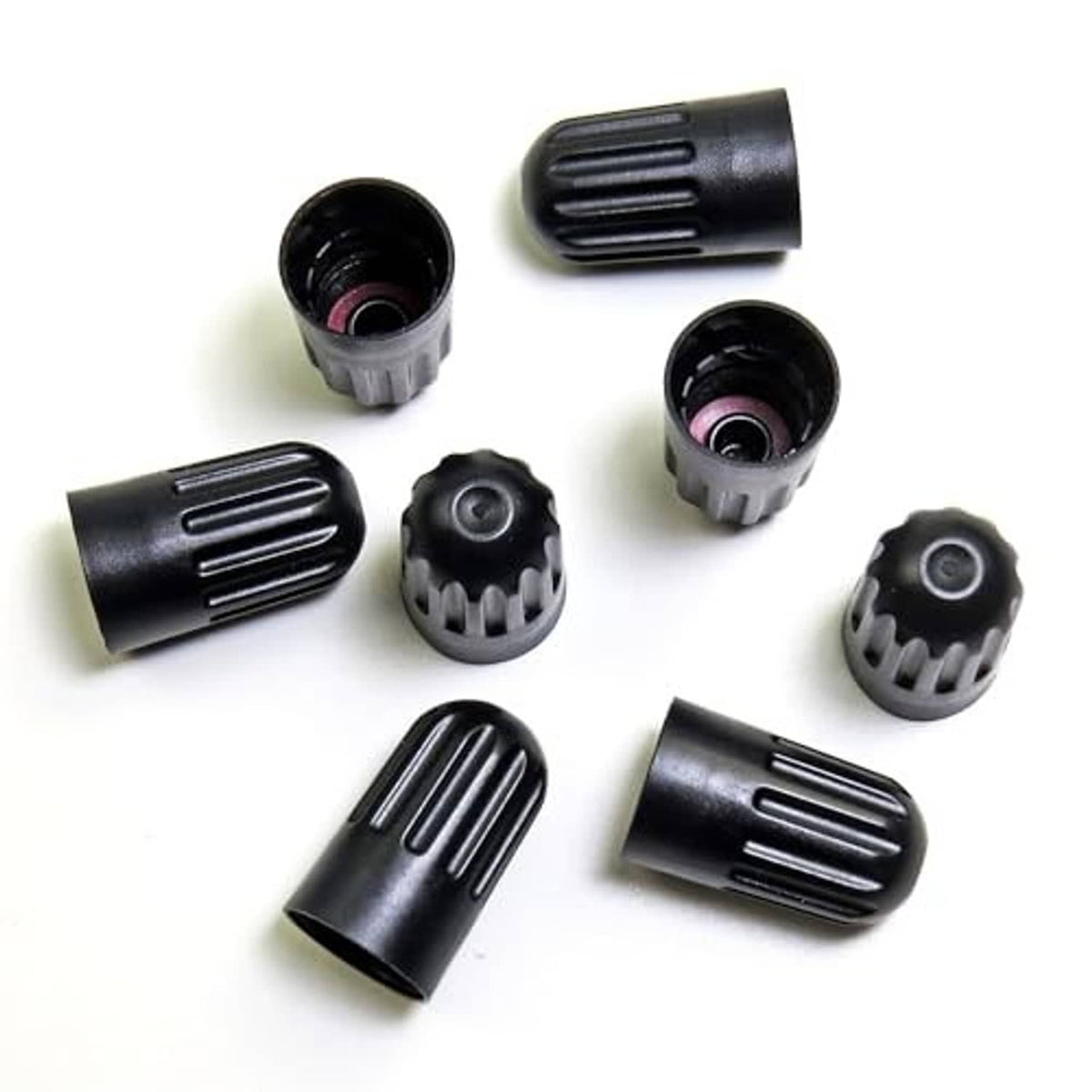 Black plastic long tire valve stem caps, ribbed tops with open end views