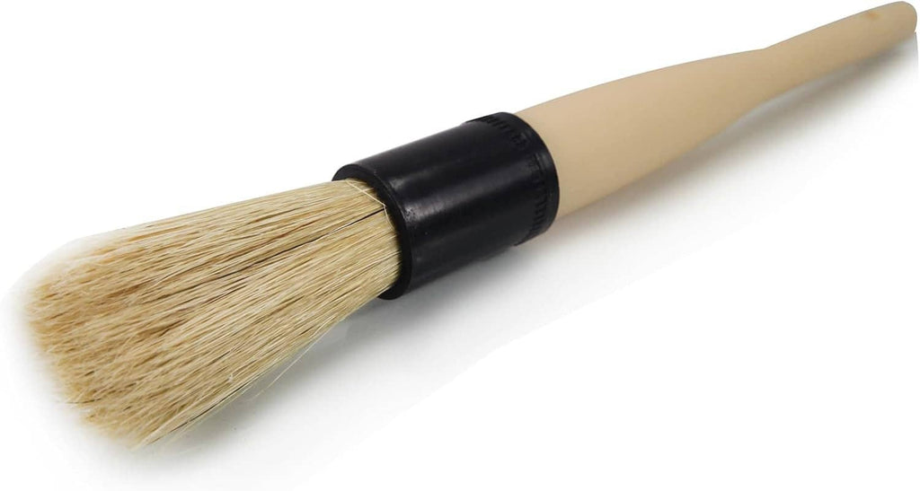 Boar hair cleaning brush with angled tan bristles on pale handle