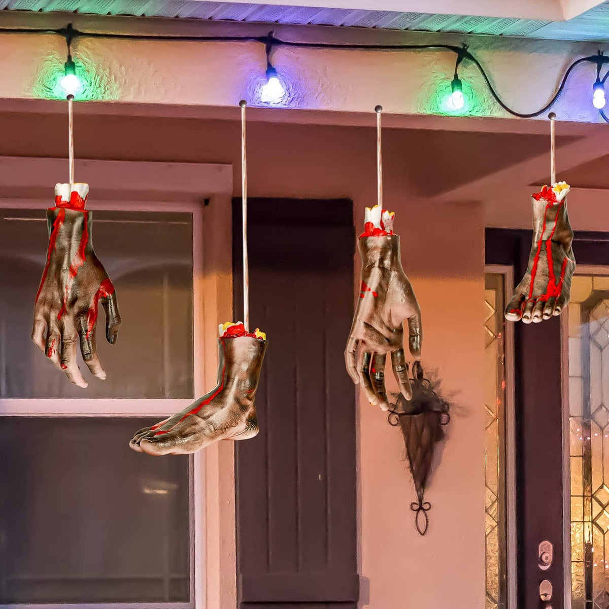 Hanging severed hands and feet Halloween props with bloody red details on gray-brown skin
