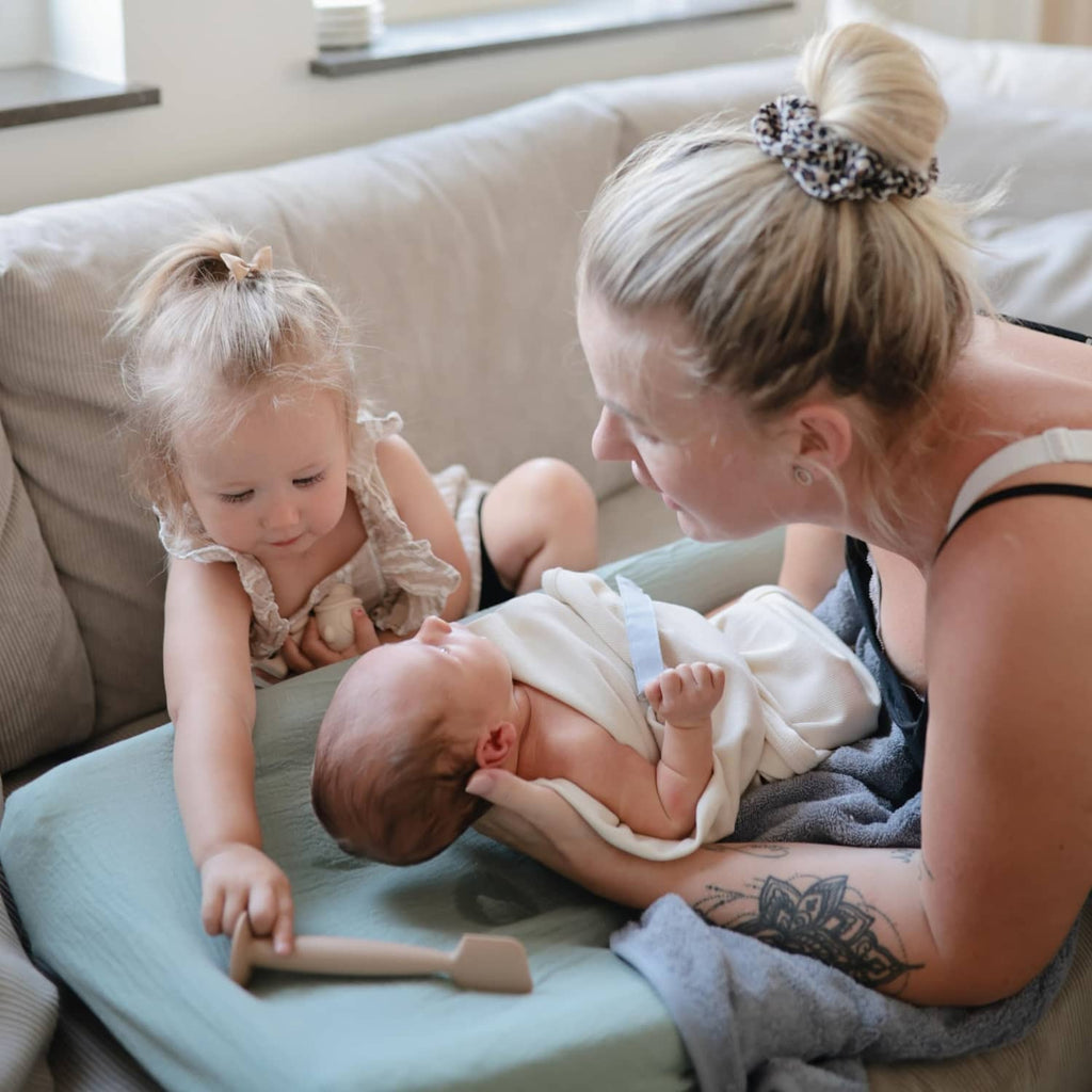 Mushie soft silicone diaper cream applicator in use during childcare