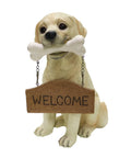 Tan Labrador puppy statue holding a white bone and a hanging “WELCOME” sign