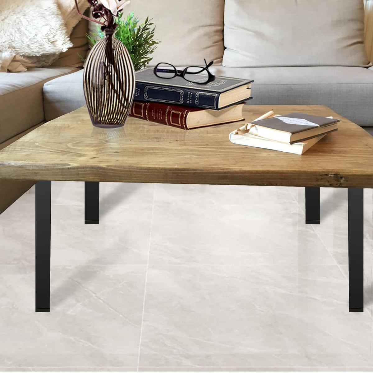 Black metal folding table legs under a wooden tabletop in a living room