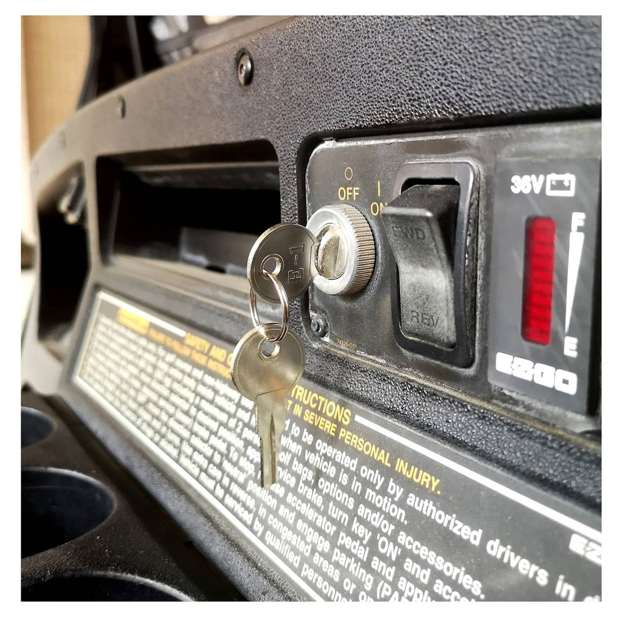 Golf cart ignition key switch with key in metal dash panel and OFF/ON markings.