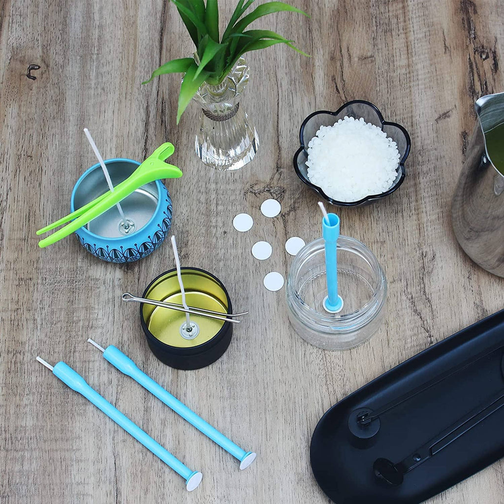 Candle wick kit tools and cotton wicks on tabletop, including blue holders and wick placement tube