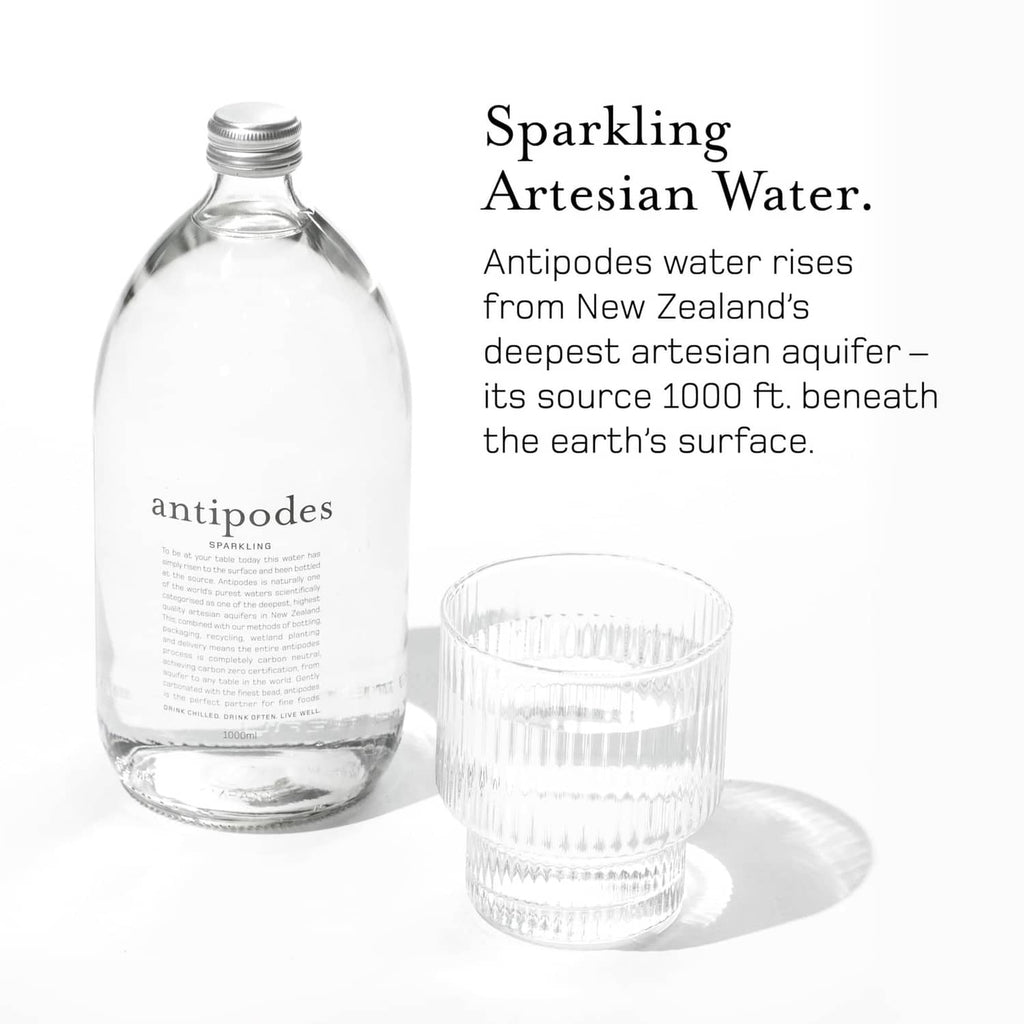 Antipodes sparkling artesian water bottle with glass cup, front label view