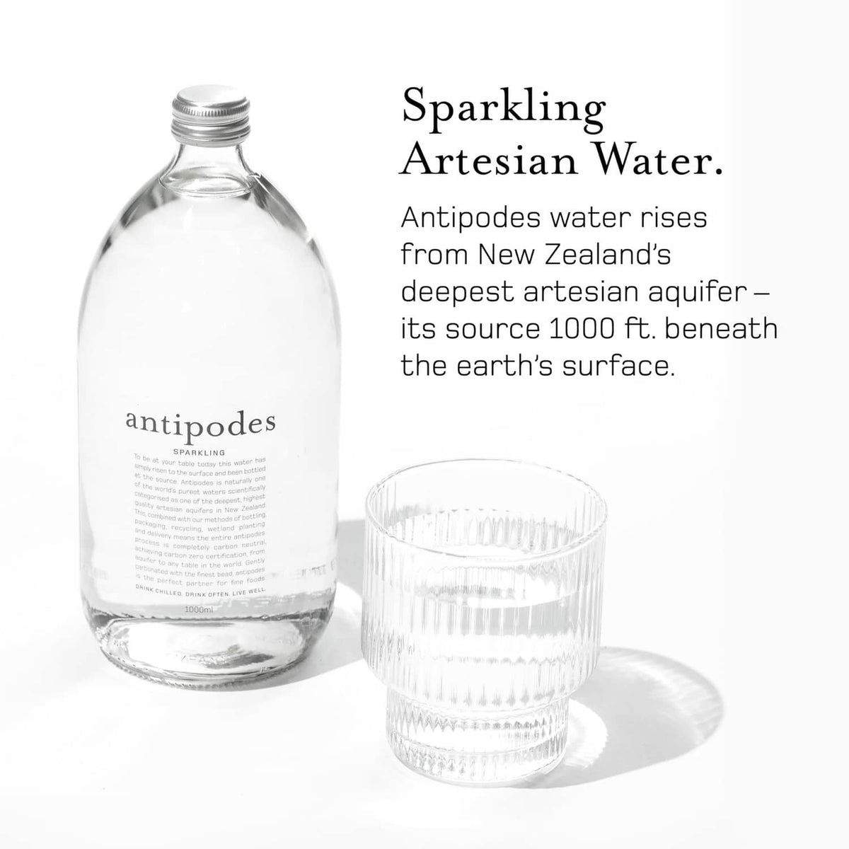 Antipodes sparkling artesian water bottle with glass cup, front label view