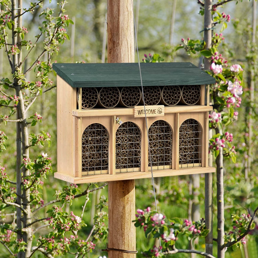 Mason bee house on a post with dark entry face and rows of nesting tubes