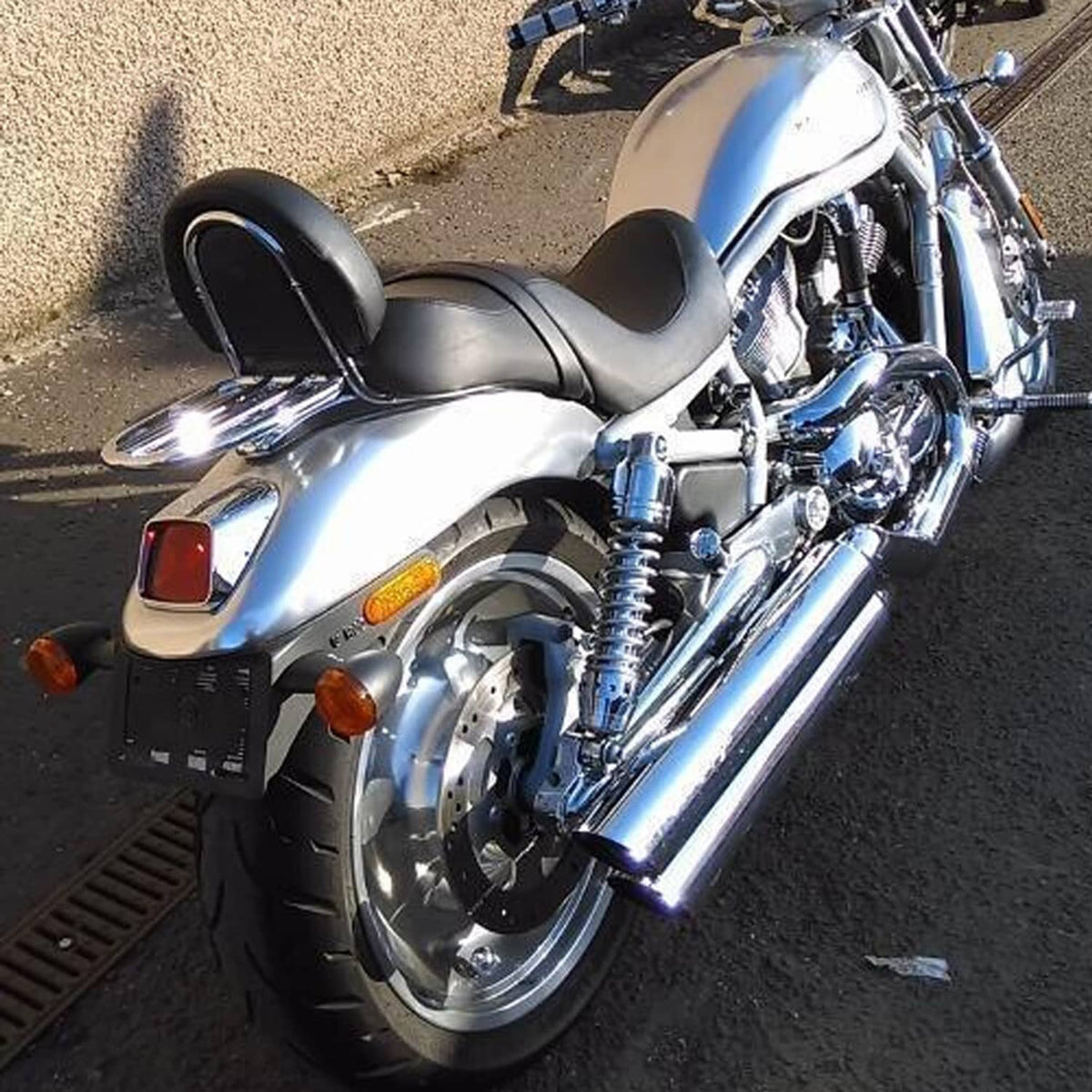 Chrome rear shock absorber on a motorcycle with visible coiled spring near the wheel