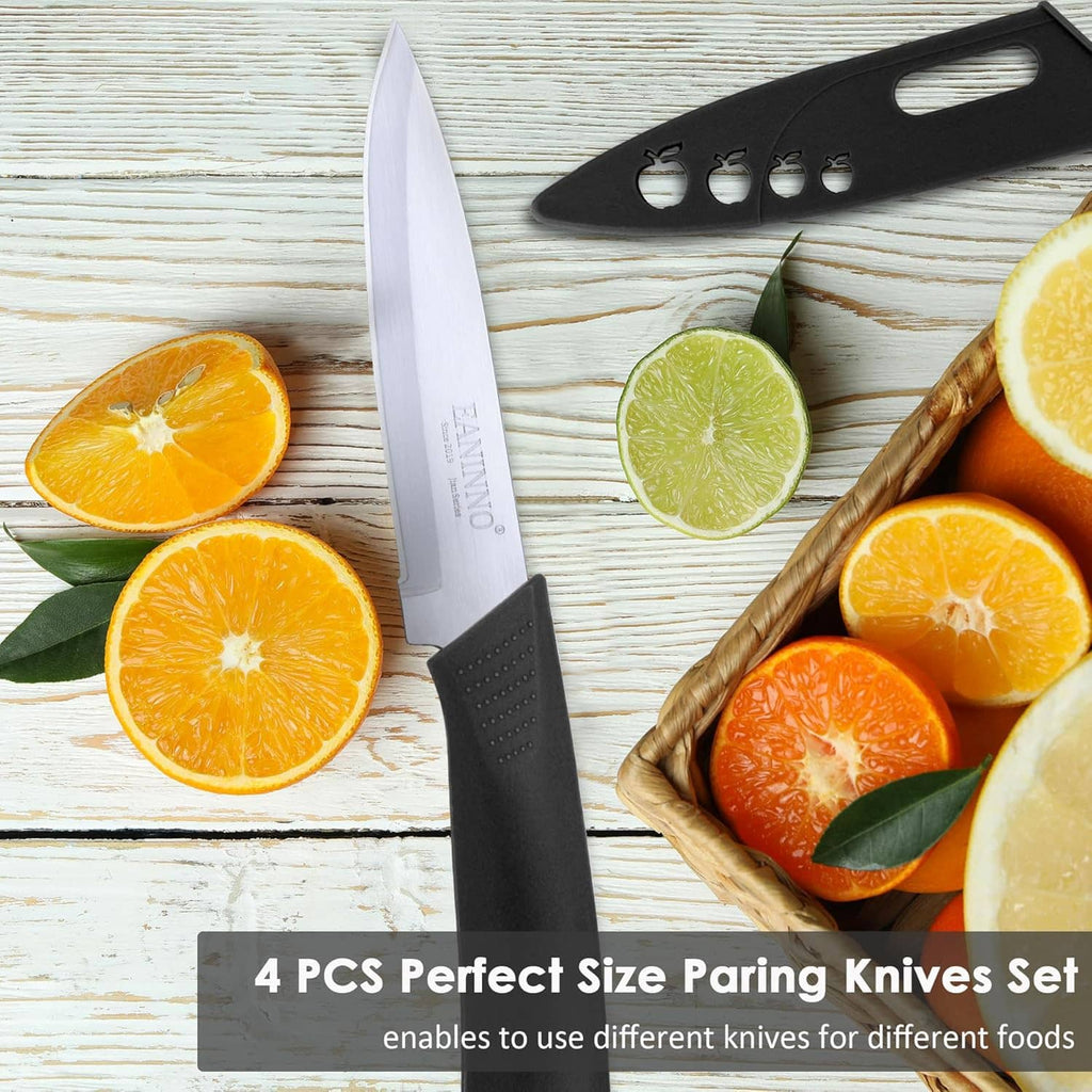 Paring knife with white blade and black handle on wooden surface with citrus slices