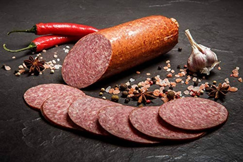 Pepperoni sausage casing slices with visible spices and peppercorns
