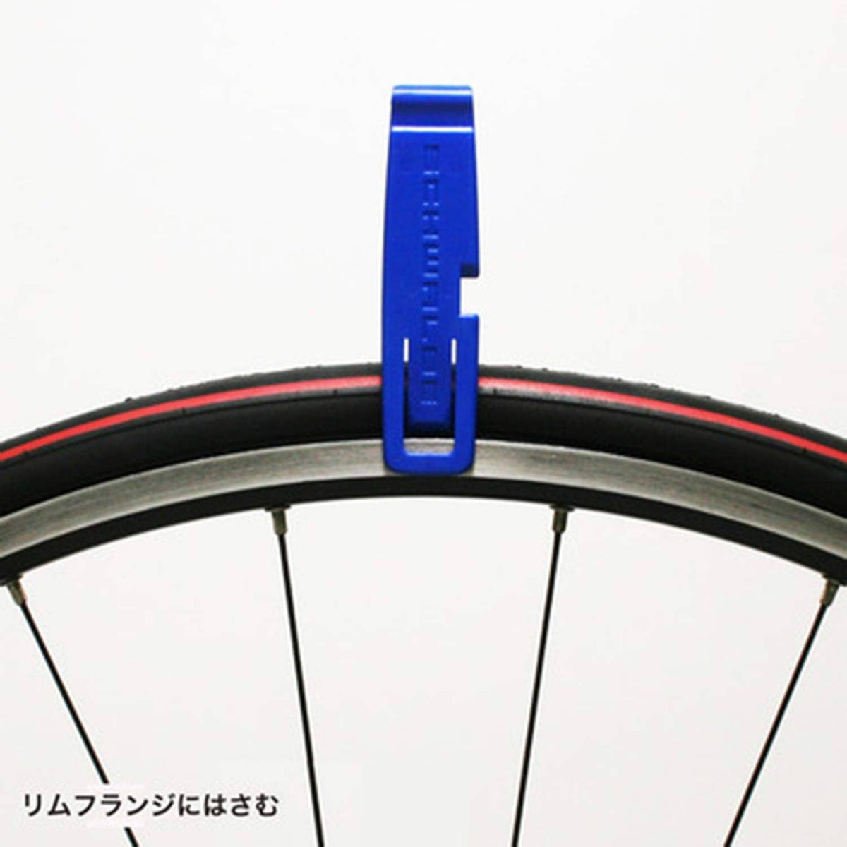 Blue tire lever standing upright on a bicycle rim between tire beads