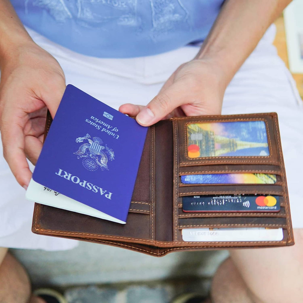Brown leather passport holder open with blue passport and card slots inside