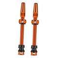 Orange Presta tubeless valve stem pair with black rubber bases and caps
