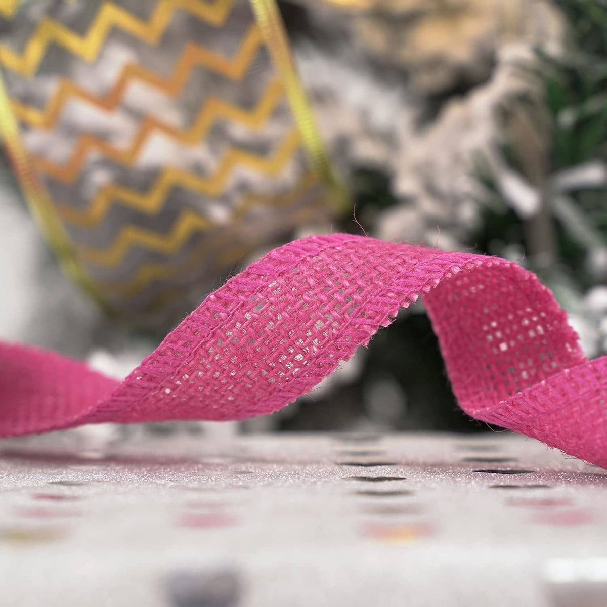 Hot pink burlap ribbon strand with woven grid texture, close-up on the surface
