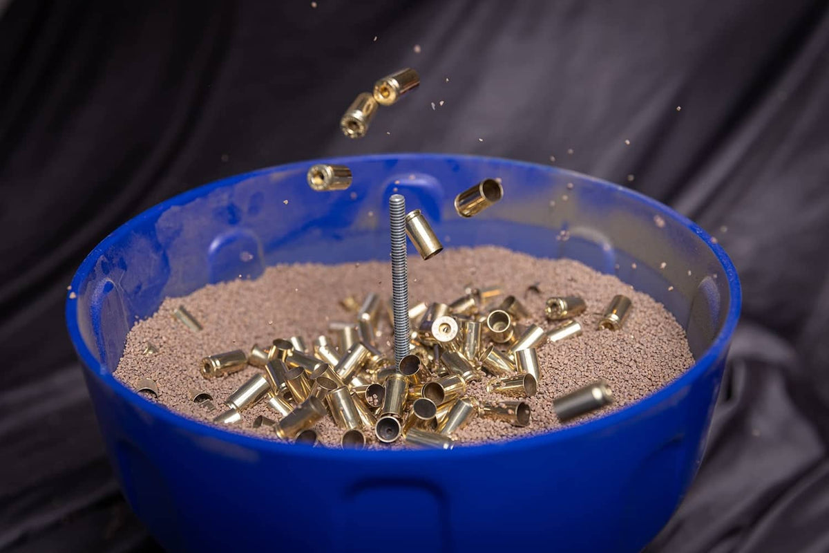 Walnut shell tumble media with mixed metal parts in a blue container