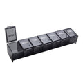 Weekly 7-day pill organizer with dark compartments labeled Mon through Sun, hinged lids