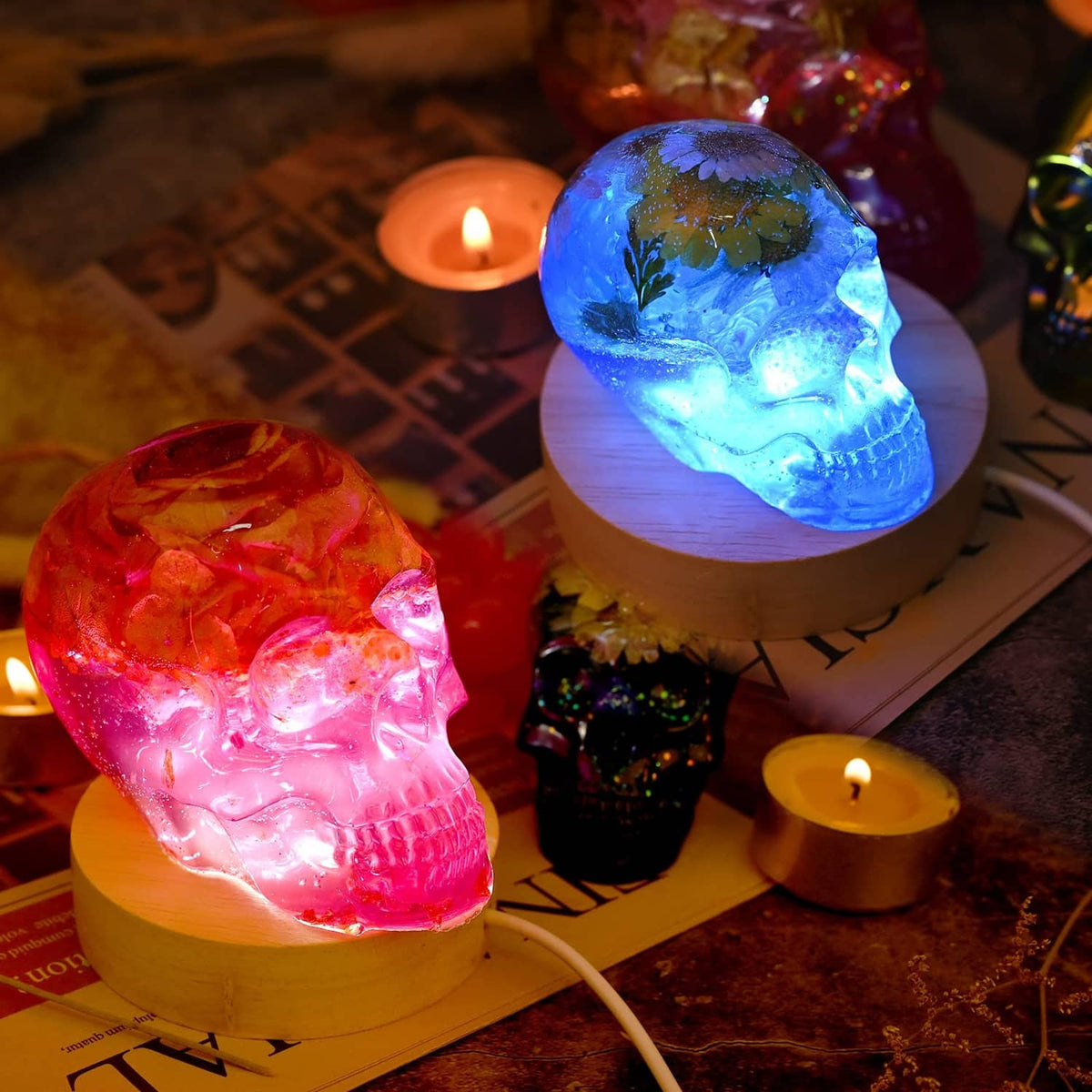 Colorful skull resin casts lit on bases, made with transparent silicone molds
