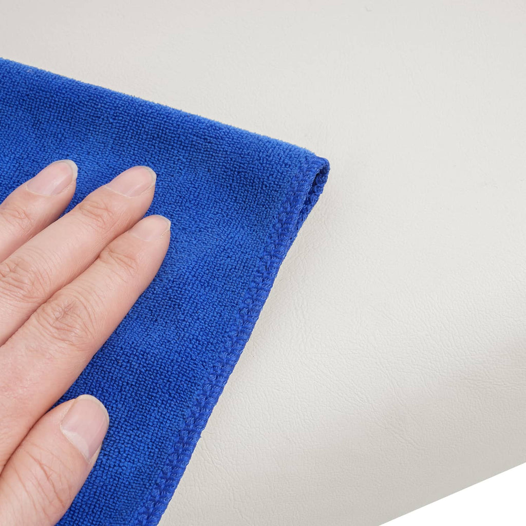 White cushion surface being cleaned with a blue microfiber cloth