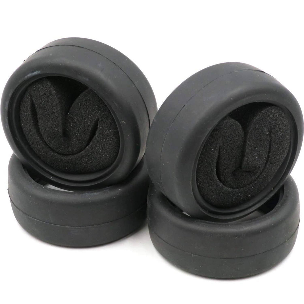 Four black RC on-road slick tires with foam inserts, front view