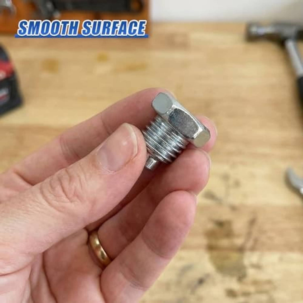 Silver hex-head bolt with threaded shank held in hand