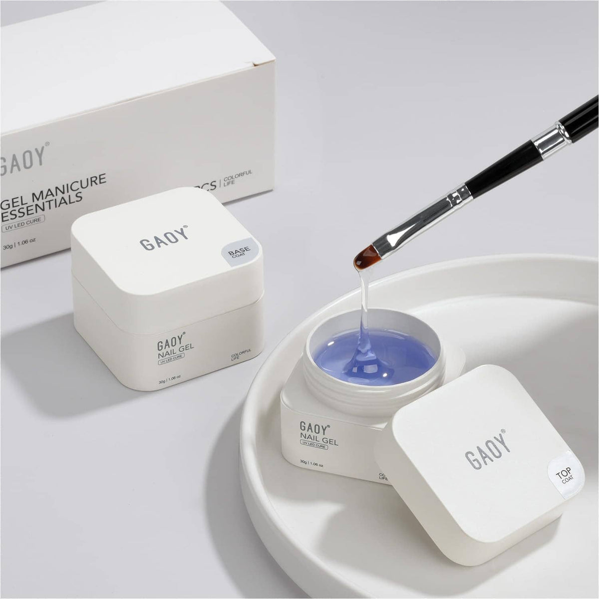 Nail gel jar with blue gel and angled brush over a white curing dish