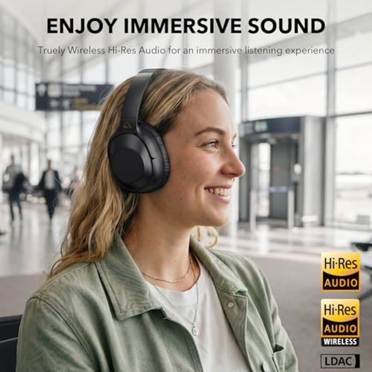 Black over-ear headphones worn by a smiling person
