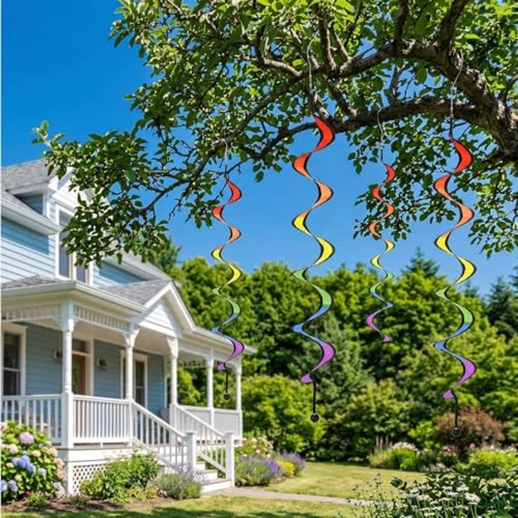 Rainbow wind spinner swirls hanging outdoors among trees and garden plants