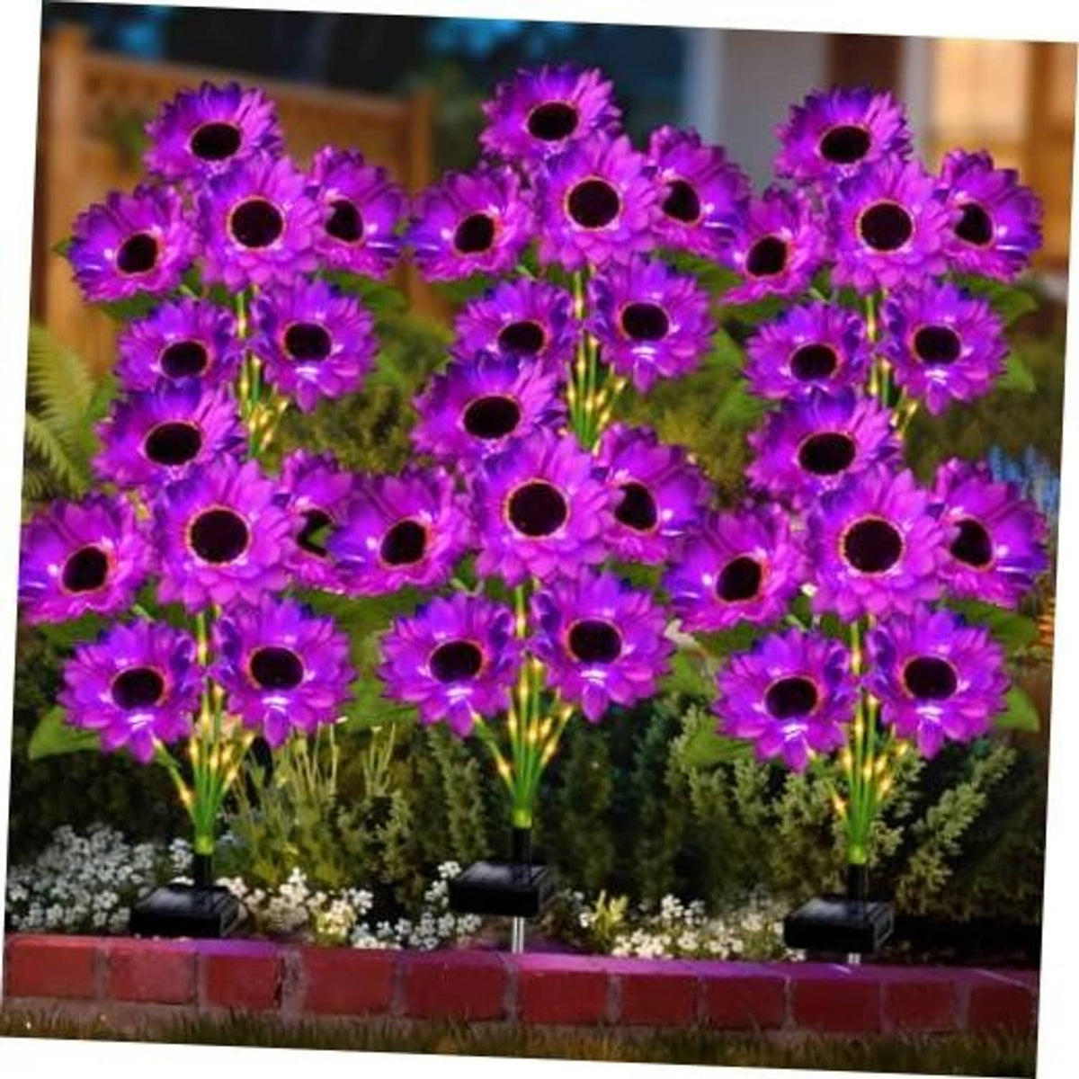 Purple sunflower solar garden lights with black base, shown in a flower bed cluster.