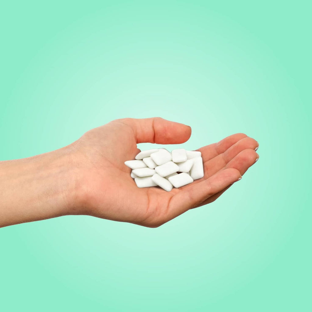 White gum pieces in hand, PUR chocolate mint xylitol flavor