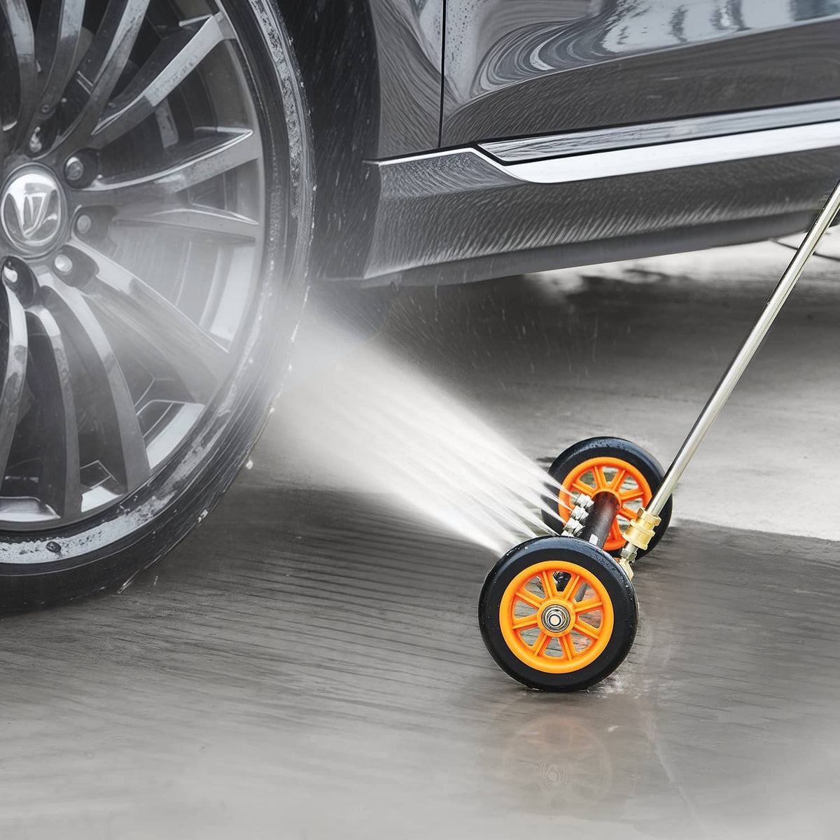 Undercarriage pressure washer cleaner spraying under vehicle with orange wheel assembly