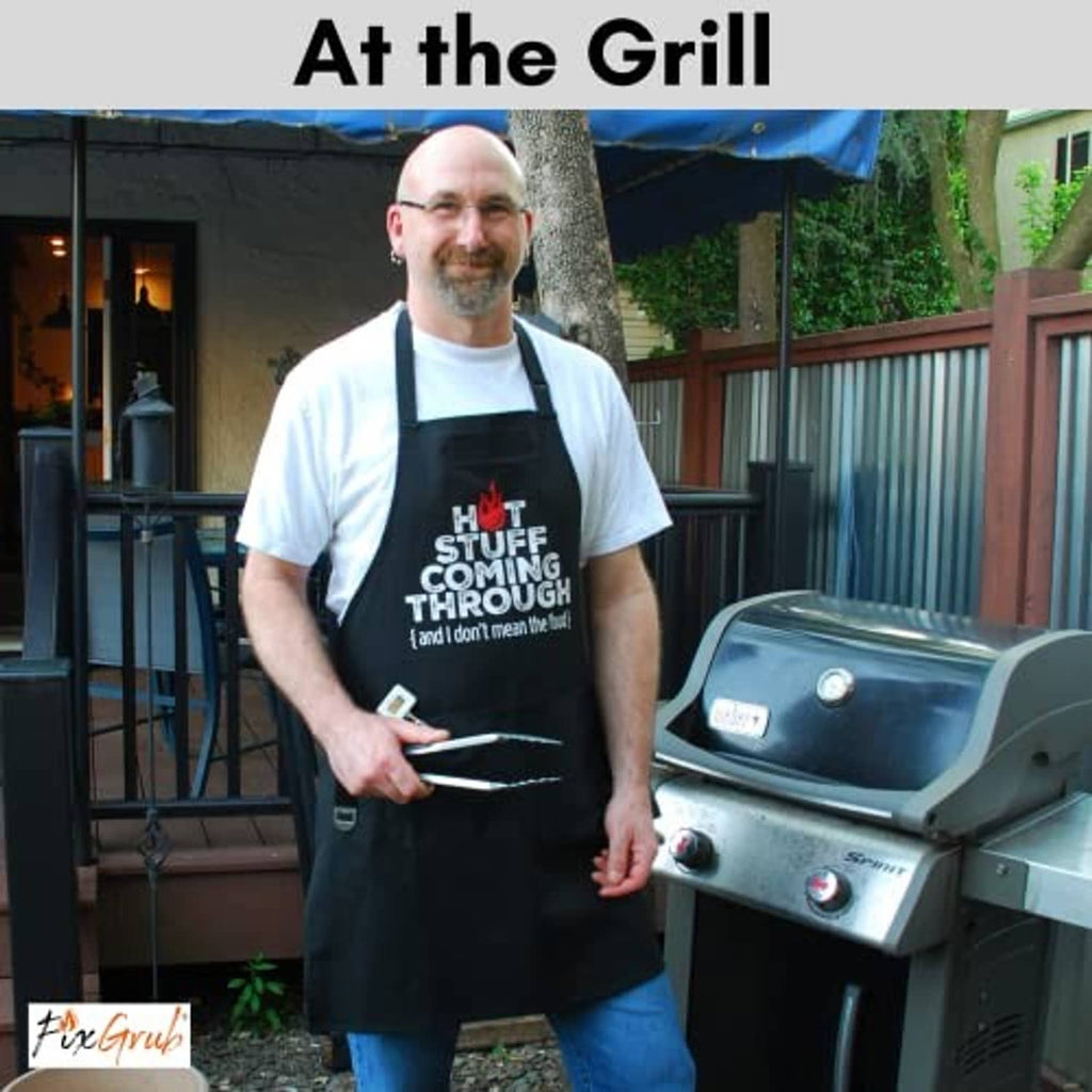Black grilling chef apron with “Hot Stuff Coming Through” slogan worn at the grill