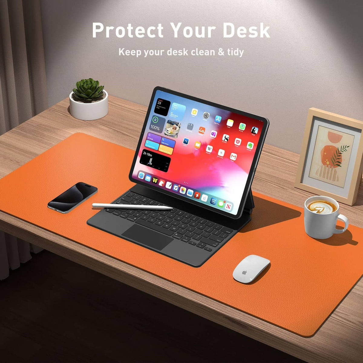 Orange desk pad protector under laptop, mouse, phone, and desk items