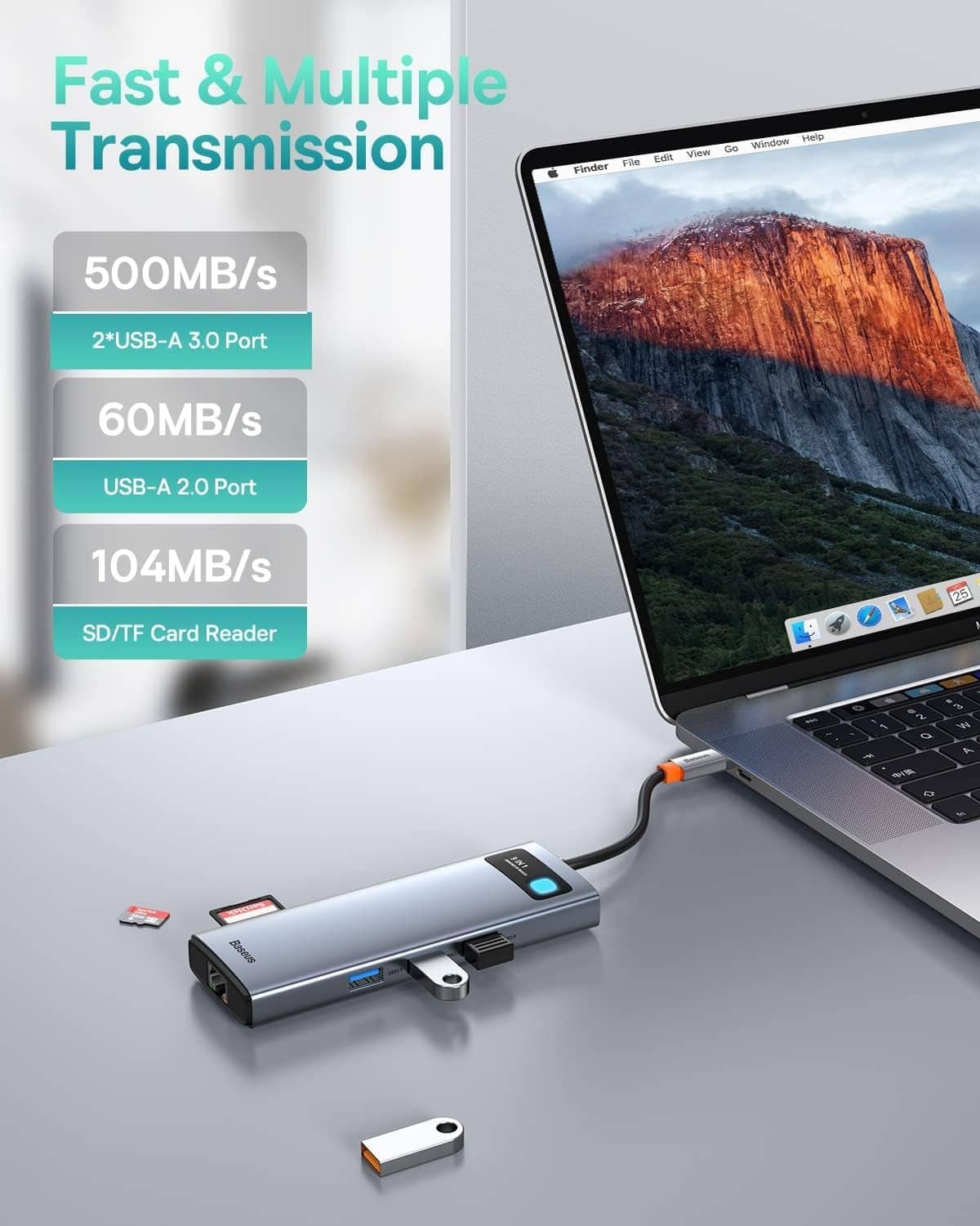 Grey USB-C hub with USB and SD card slots, blue indicator, connected to laptop