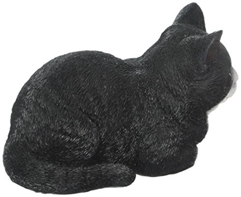 Sleeping cat statue, black with white underside accents, lying on side